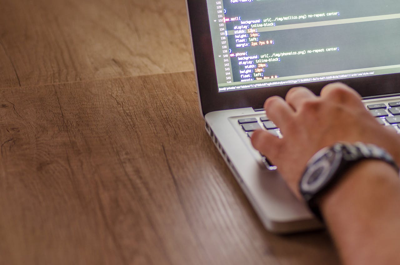 Home Close-up of a person coding on a laptop, showcasing web development and programming concepts.
